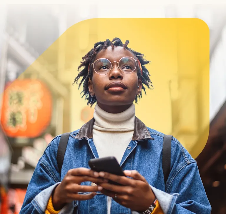 Photo of a smiling woman looking upward with phone in hand, surrounded by text describing what EQ Bank offers: high interest, unlimited transactions and no monthly fees, with EQ Bank jewel symbol set against city backdrop.